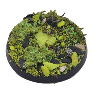 Round miniature landscape base with greenery and rocks on a white background