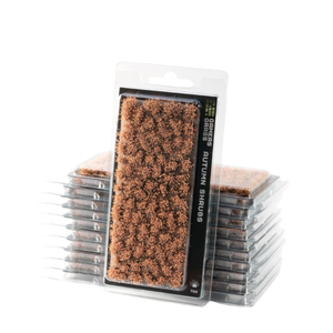 Packaged miniature terrain pieces labeled 'Autumn Shags' in a clear blister pack, with multiple stacks of the same product visible behind the front package on a white background.