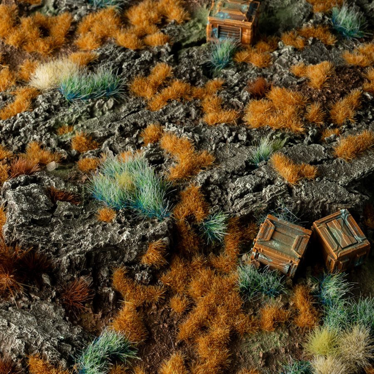 Miniature landscape with rocks, grass, and small wooden structures.