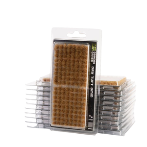Packaged dry tuft brush standing upright in the center, with several clear plastic packages of the same brush stacked behind it on a white background.