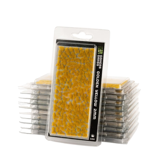 Packaged miniature grass mat in golden yellow, displayed in front of a stack of similar clear plastic packages on a white background.