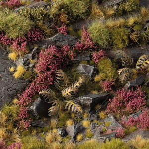 Miniature landscape with pink heather, green grass, and rocks.