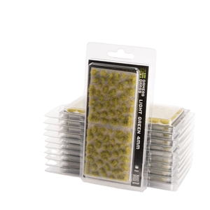 Pack of miniature terrain grass pieces labeled 'LIGHT GREEN 4mm' in clear plastic blister packaging, with stacks of the same package behind it on a white background.