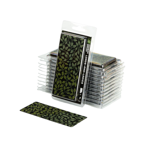 A pack of playing cards with a dark green and black leaf pattern, shown standing upright in its clear plastic blister packaging with several stacks behind it and one card placed in front on a white background.