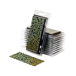 A pack of X-Files 1/6 scale plastic model wings in a green and black leaf pattern, shown with several stacks of clear plastic-wrapped wings and one wing displayed outside the package on a white background.