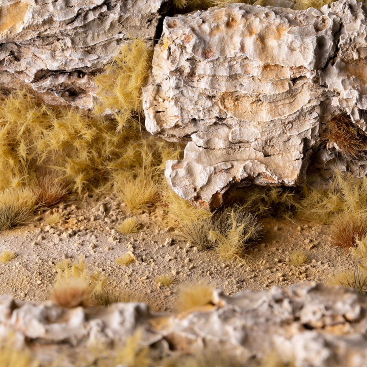 Close-up of textured rocks and dry grass in a natural setting